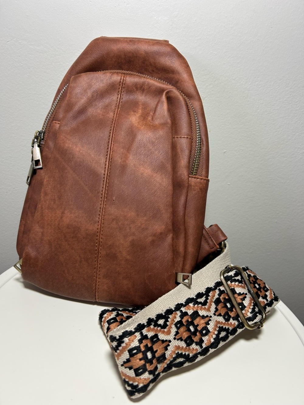 Brown Faux Leather Sling Backpack with Patterned Strap